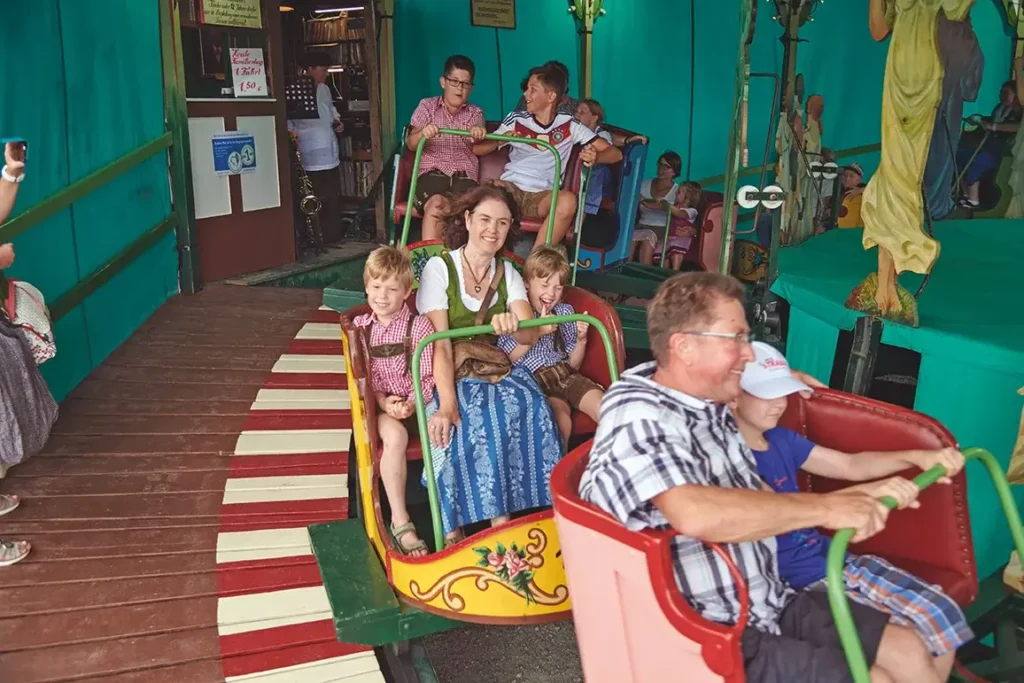 Kinder und Eltern in einem alten Fahrgeschäft am Gäubodenvolksfest