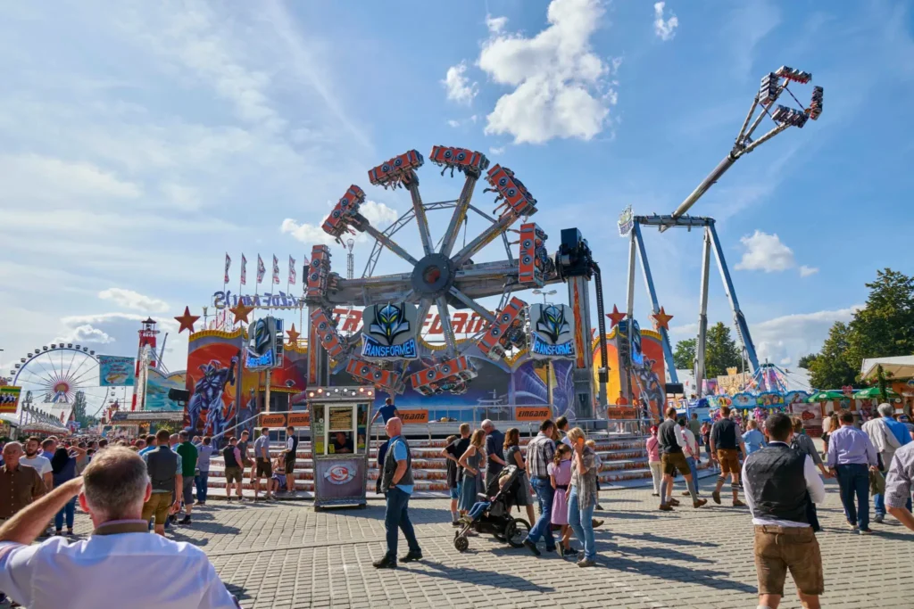 Blick auf ein Fahrgeschäft am Gäubodenvolksfest mit Besuchern in Tracht